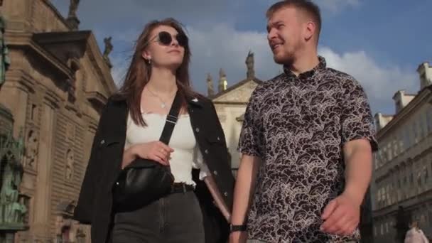 A young couple holds hand on a walk in the old city. Tourist walk in a new place — Vídeo de Stock