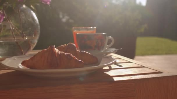 Desayuno retroiluminado en la mesa. Croissants, sandía. Listo para comer. — Vídeo de stock