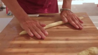 Eller hamuru ahşap tahtada yuvarlar. Yemek pişirmek için boşluk..