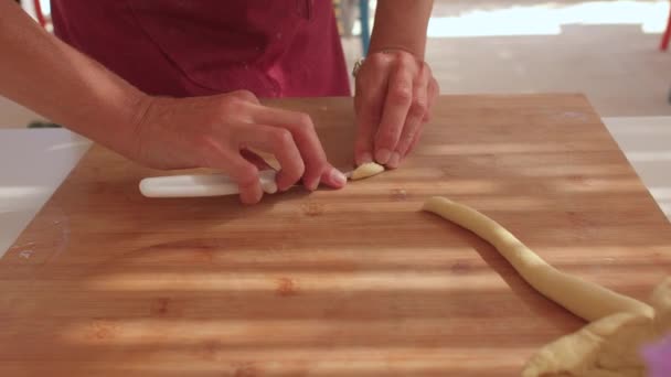 Hands cook cut dough on board. She cuts off pieces, puts her hands. — Stockvideo
