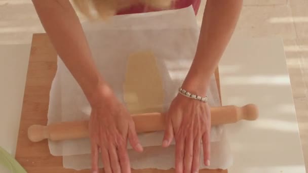 Mujer chef lanza la masa con un rodillo. Usa papel para hacer artesanía.. — Vídeo de stock