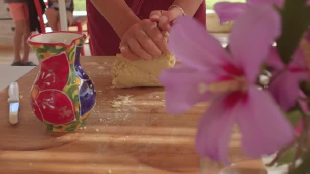 Las manos amasan la masa sobre una tabla de madera. Presiona la pelota con las manos. — Vídeos de Stock