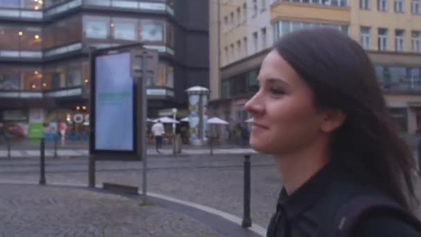 Mujer retrato en movimiento. Da pasos por la ciudad, mira a su alrededor — Vídeo de stock