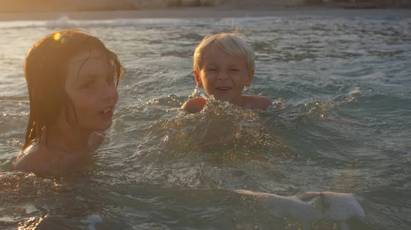 Gelukkige jongens zwemmen in de zee. De voordelen van de zee voor de gezondheid van kinderen. — Stockfoto
