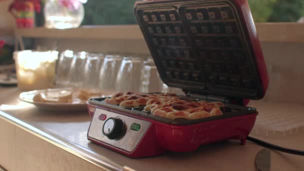 Chef hand opens waffle iron table She takes out ready-made waffles, uses knife — стоковое видео