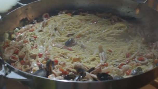 Closeup a dish of pasta and seafood. Adding water to the pan according to recipe — Video Stock