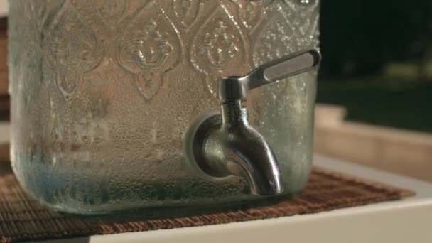 ガラス瓶の中の蛇口。冷たい水を注ぎ、渇きを癒す. — ストック動画