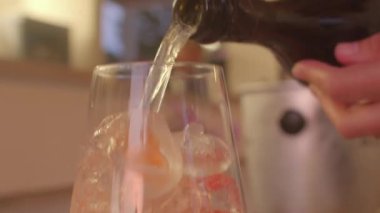 Şişelenmiş soda kabarcıklarıyla dolu yakın çekim içecek bardağı köpüklü köpük oluşturur.