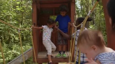 Erkek ve kız kardeşler el ele yürür. Bebekli ebeveynler çocuğu dikkatle izliyor