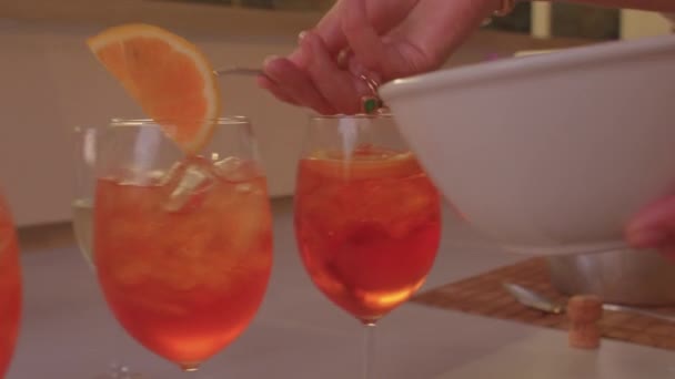 Bereiding van alcoholische drank. Decoratie glazen met sinaasappelschijfjes. — Stockvideo