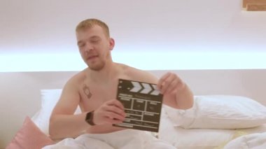 Bir adam sahneyi başlatmak için film sehpası kullanır. Atış talimine başla.