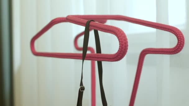 Bra hanging on red hanger woman leaves laundry before resting body. — Vídeo de Stock