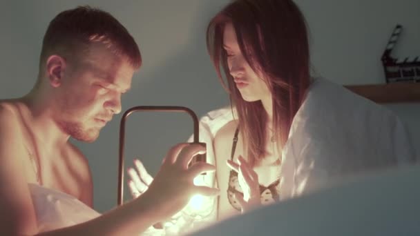 Man and woman playing lamp in bed They move their hands around light — 图库视频影像