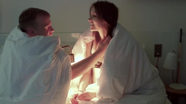 Man and woman covered blanket using lamp man touches girl hair — Wideo stockowe