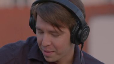 İlham veren müzisyenler kulaklıklarını çıkarırlar. Adam gülüyor, kadın kafa sallıyor.