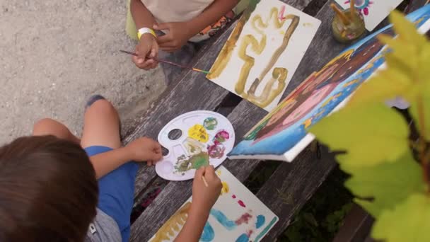 Τα παιδιά ζωγραφίζουν με χρώματα στην ύπαιθρο. Στο πάνω μέρος. Ανάπτυξη δημιουργικότητας. — Αρχείο Βίντεο