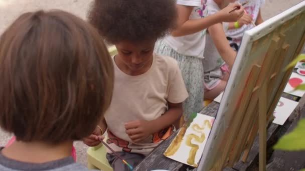 Laboratorio di pittura per bambini nel campo d'arte. I bambini dipingono con vernici all'aria aperta. — Video Stock