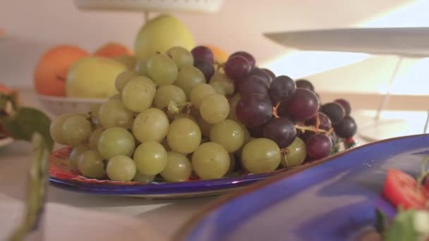 Served table with fresh fruits at breakfast in buffet. Grapes, bananas close-up. — Stock video