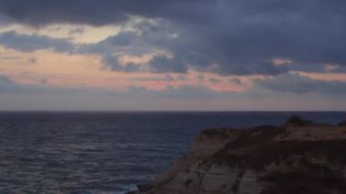 Timelapse of the movement of the sea and clouds at dawn. Stone coast.