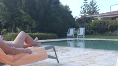 Sunbathing by the outdoor pool at summer. Spending time in the sun.