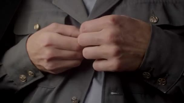 Close-up of hands fastening buttons on a gray uniform. The distinctive clothing. — Stock Video