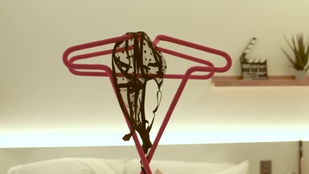 黒の女性のブラジャー付きの赤いハンガー。ベッドの前で服を折る場所. — ストック動画
