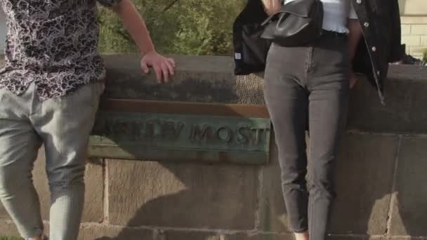 Een afspraakje voor een liefhebbend stel. Charles Bridge inscriptie op een metalen plaat. — Stockvideo