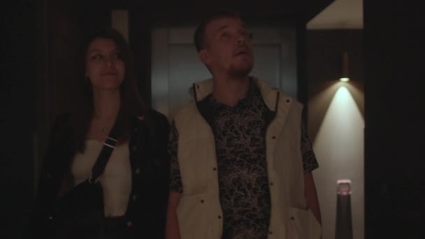 Couple se déplace le long du couloir sombre de l'hôtel. Taches lumineuses sur le mur. — Video