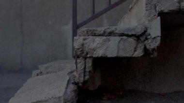 Terk edilmiş bir binadaki gri kırık beton merdivenlerin yakınına..