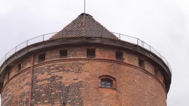 Средневековая красная кирпичная башня с окнами в качестве туристической достопримечательности. Оборонительное здание — стоковое видео