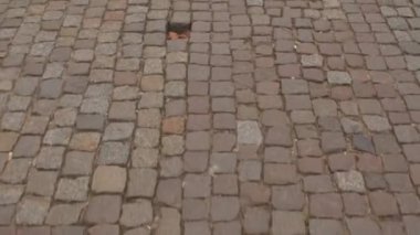 Eski şehirde bir yayanın ayağının altındaki kaldırım taşlarının hızlı hareketi..