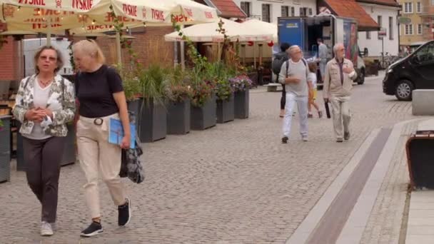 Parejas jubiladas caminan por la parte turística de una antigua ciudad europea. — Vídeo de stock