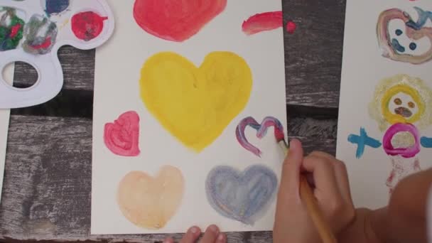 Los niños pintan corazones con pinturas al aire libre. Señal de amor. Taller de pintura — Vídeos de Stock