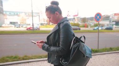 Şehir caddesinde bir kadın cep telefonu kullanıyor. Mobil uygulama kullanılıyor