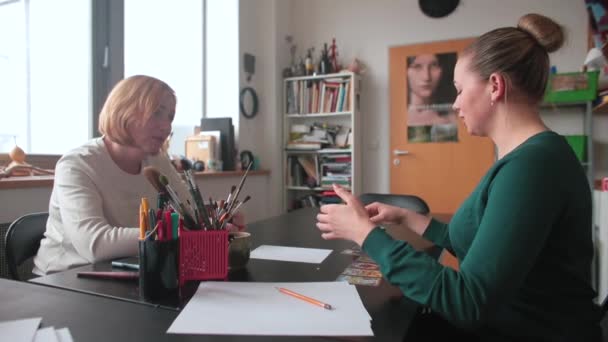 Due donne stanno parlando al tavolo. Scambio di informazioni durante le sessioni di terapia. — Video Stock