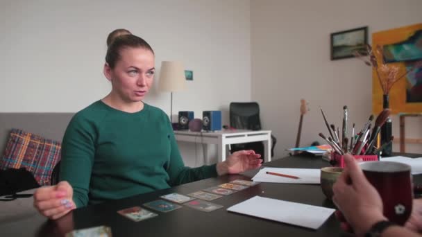 Una mujer durante una sesión con un terapeuta gestáltico usando tarjetas metafóricas. — Vídeo de stock