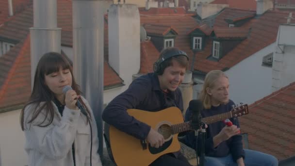 Groupe étudiants fait de la musique sur le toit de la maison Ils jouent et chantent activement — Video