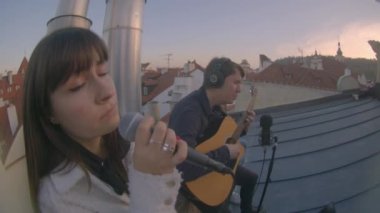 Kız mikrofona şarkı söylüyor. Ritmik hareketler vücut müziği yener.