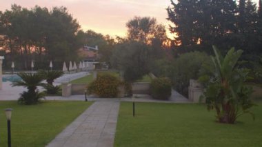 Bahçe yolları gökyüzü sarı parlıyor. Bahçe tropik ağaçları 