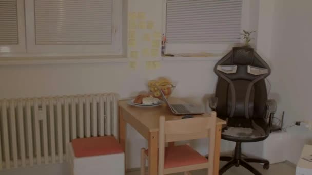 Ein Zimmer in einer Wohnung. Tisch mit Laptop. Ein Sessel, eine Lampe leuchtet. — Stockvideo