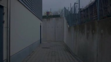 Binanın yakınındaki beton geçit. Gri lekeli duvarlar. Köşe hareketi.