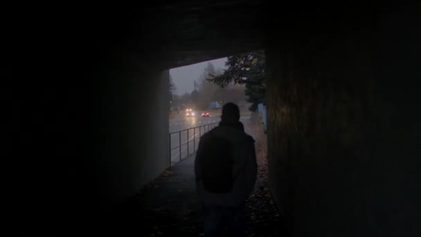 Człowiek porusza się w ciemnym korytarzu. Wychodzi poza ruch samochodów, reflektorów. — Wideo stockowe