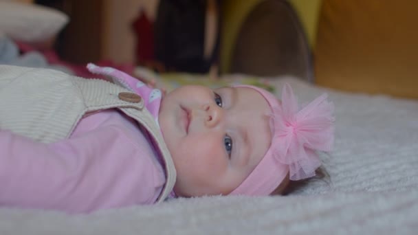 Retrato de una linda niña con un adorno rosa en el cabello. Estereotipos de género. — Vídeos de Stock