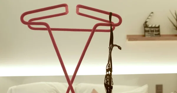 Woman hand threw her bra onto a red hanger place fold clothes before bed. — Stockfoto