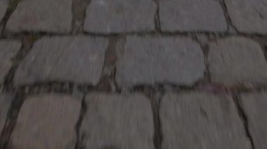 Eski şehirde bir yayanın ayağının altındaki kaldırım taşlarının hızlı hareketi..