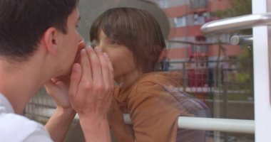 Aile üyeleri hastalık nedeniyle karantina sırasında cam yoluyla iletişim kurarlar..