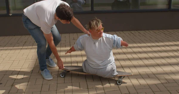 Guy aide une personne handicapée à acquérir une nouvelle compétence et une nouvelle expérience — Photo