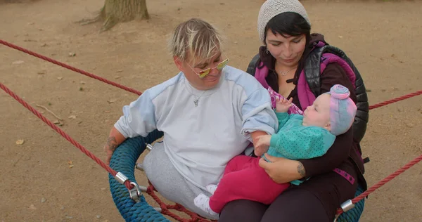 Eine behinderte Frau zusammen mit einer Mutter und einem Kind. — Stockfoto