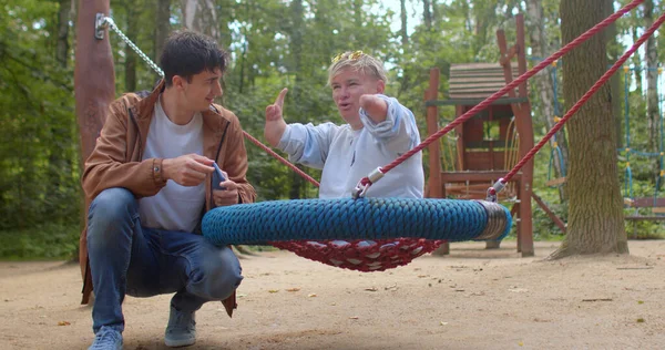 Un travailleur social communique avec une personne handicapée dans le parc urbain. — Photo