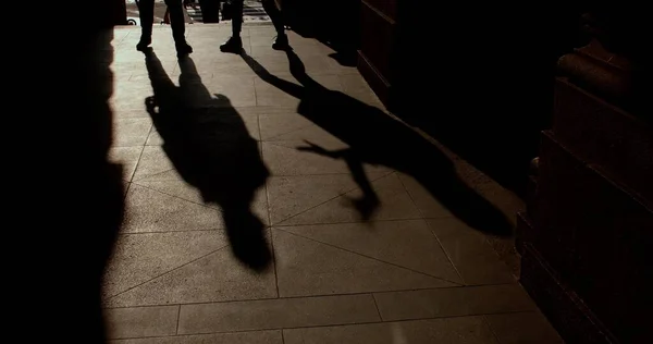 Силуэты преследуют людей на тротуаре в городе. Они двигают руками и ногами.. — стоковое фото